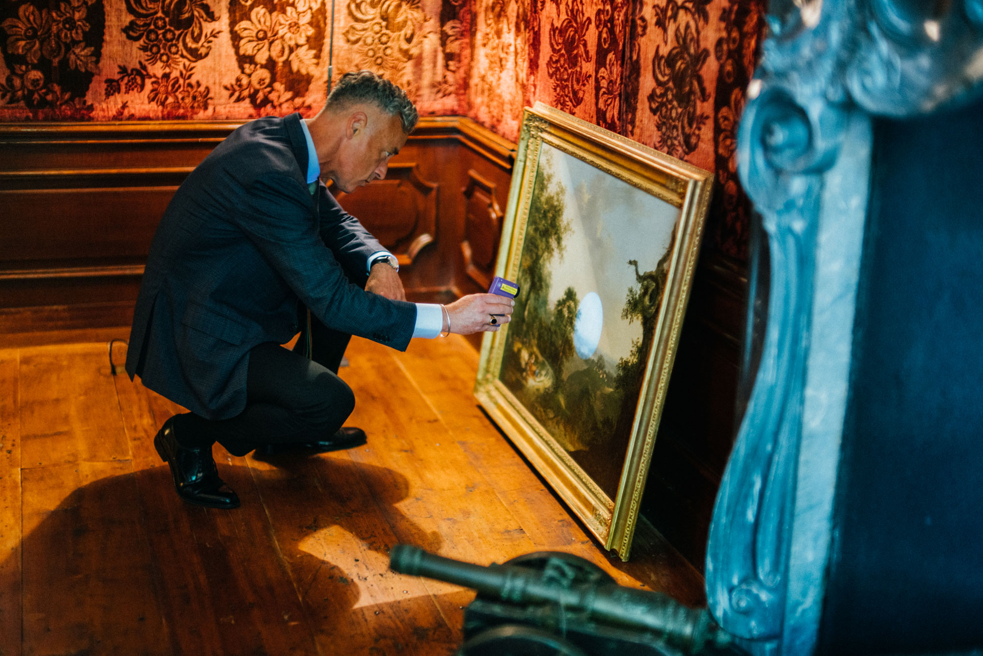 Patrick van Karsen onderzoekt een schilderij tijdens een taxatie